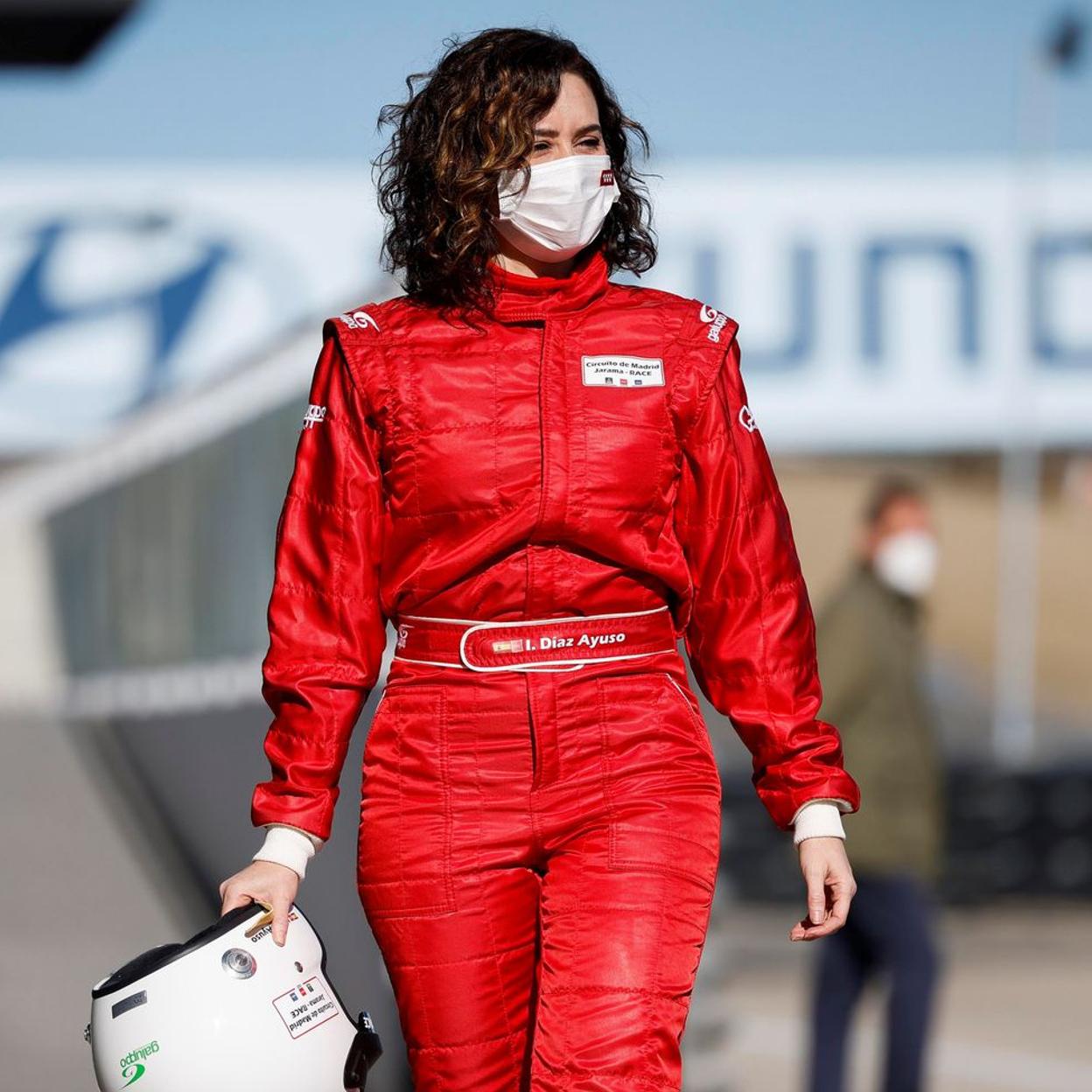 Isabel Díaz Ayuso posa con mono rojo y casco en el circuito madrileño del Jarama. 
