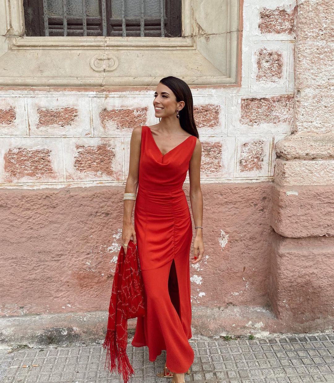Una invitada de rojo nunca falla, y Laura Corsini consigue un look de boda impecable con este vestido de fiesta súper favorecedor: el drapeado de la cintura y cadera estiliza y disimula tripita. El look, por supuesto, es de Bimani.