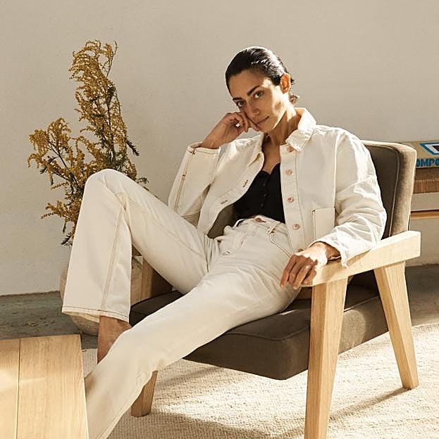 Imagen principal - El sillón de madera cuesta 599 euros y la mesa de roble, 499 euros. El banco de madera reciclada cuesta 149 euros y la manta, 69.99 euros. El taburete de fresno cuesta 79.99 euros.