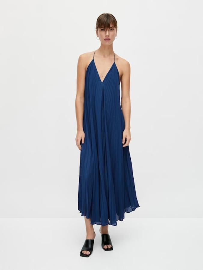 Confeccionado en tejido fluido, con cuello de pico y tirantes finos, este vestido largo plisado con diseño en evasé y bajo asimétrico tiene un precio de 129 euros. 