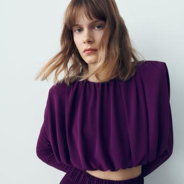 Imagen secundaria 1 - Puedes llevarla en total look, con el pantalón morado que te propone Zara, o en contraste con un diseño fluido de color blanco. Blusa drapeada con hombreras de Zara (19,99 euros) 