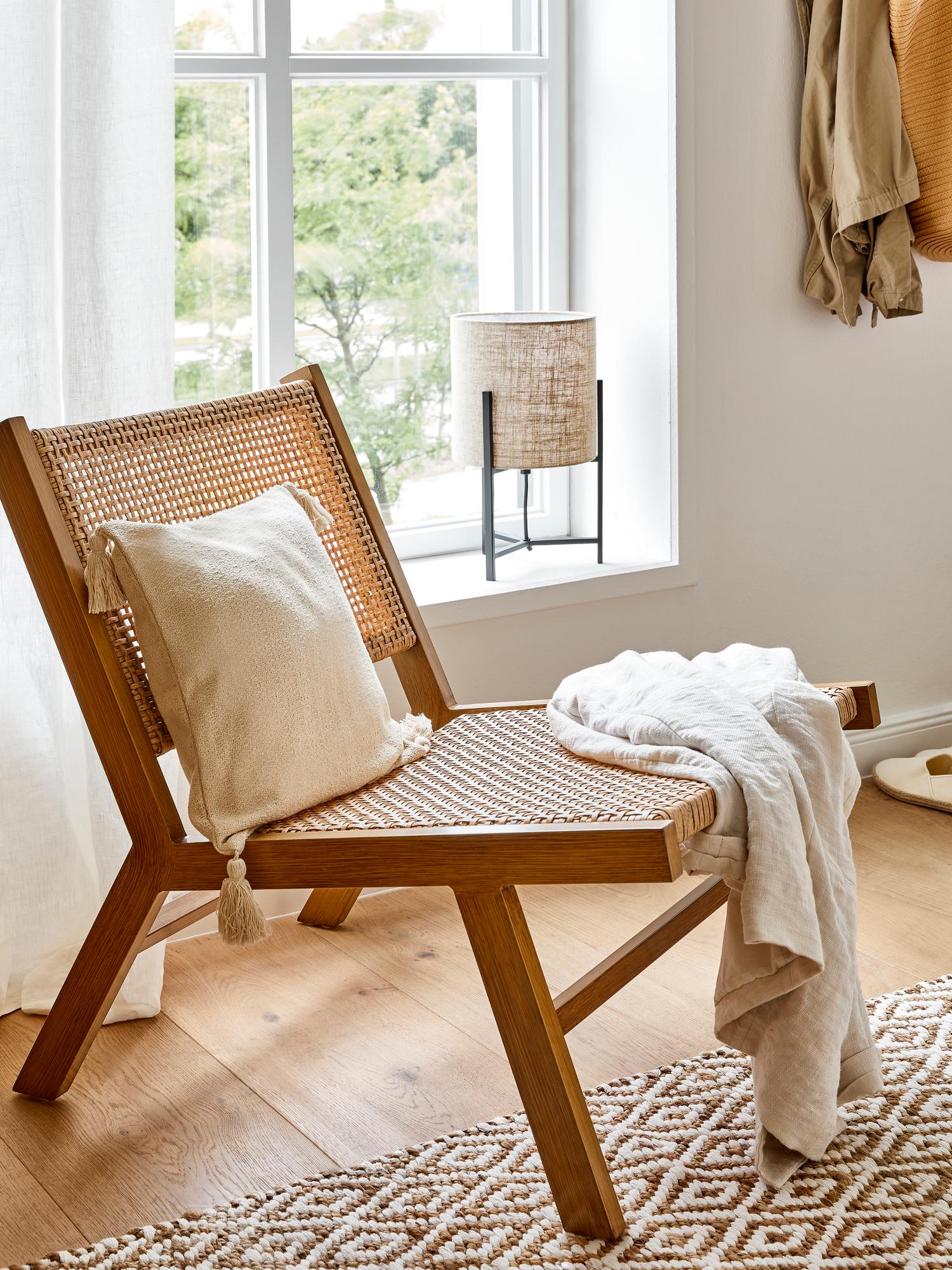 Una de nuestras opciones favoritas es esta versión de inspiración retro del sillón lounge en madera y ratán de Westwing, que cuesta 179 euros.