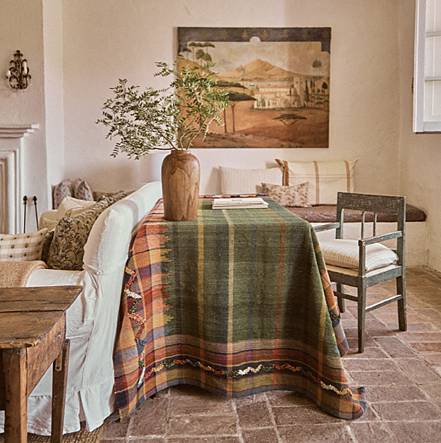 Imagen principal - En Zara Home, la alfombra de cuadros, colocada a modo de mantel, cuesta 299 euros; los jarrones de madera, 59.99 euros, y los de cerámica rústica, 49.99 euros; la lámpara de pie cuesta 149 euros, y los cojines, con varios tamaños, formas y estampados, desde 19.99 euros.