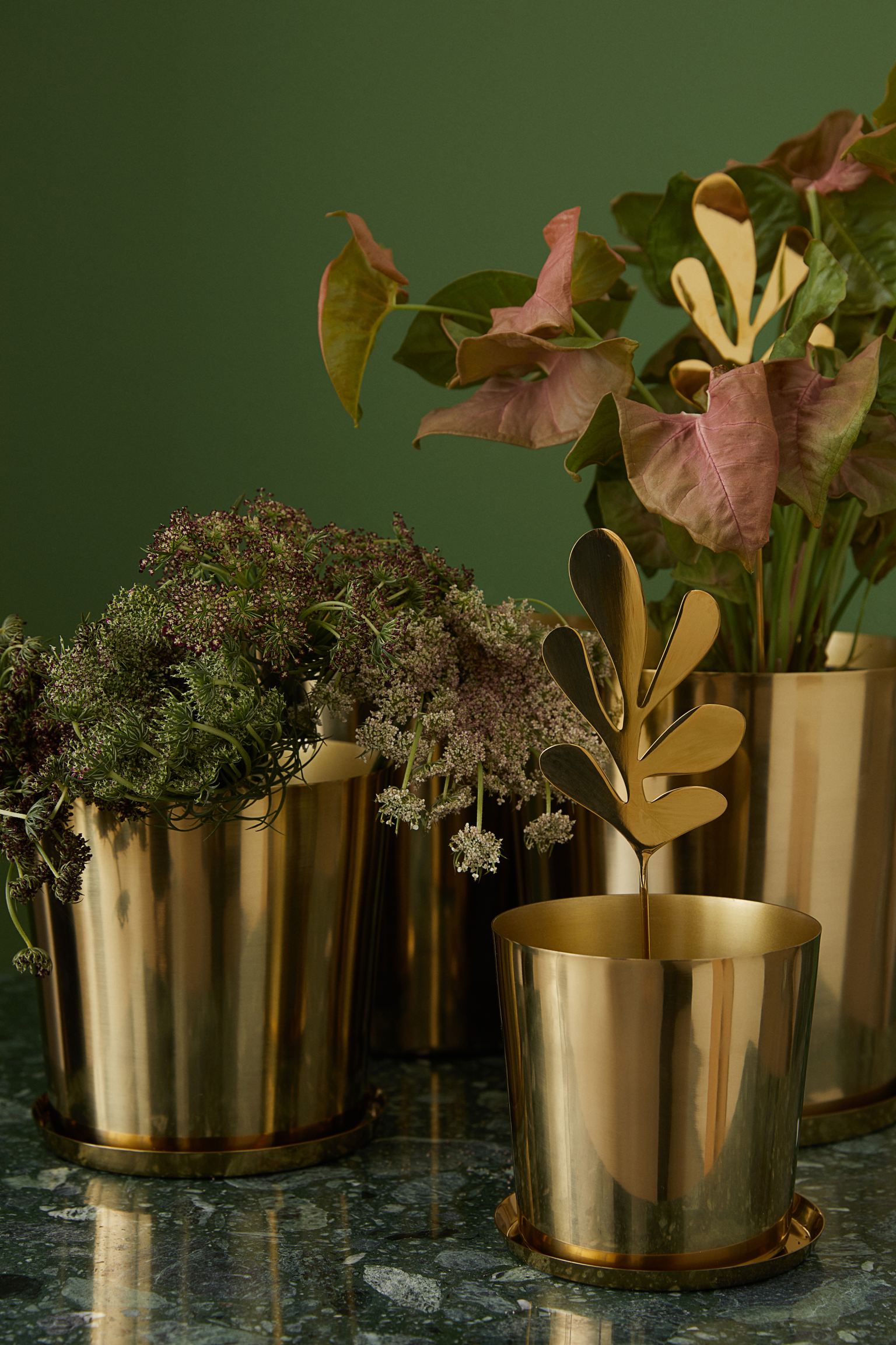 La decoración con plantas está cada vez más de moda, y no es para menos. Aporta color y vida a los espacios, además de dotar de frescura y amplitud. Nos encanta jugar con los maceteros, con diferentes tamaños, formas y acabados, e introducir adornos como este en meatlizado dorado, que cuesta 4.99 euros en H&M Home.