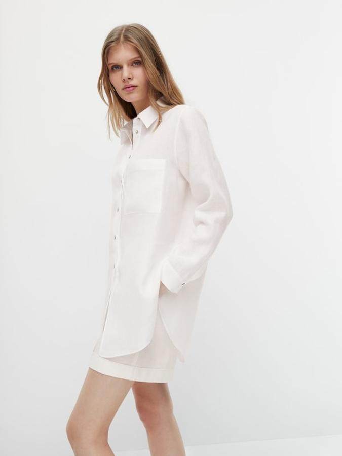 Con cuello de pico y cierre frontal de botones, este bonito y cómodo blusón blanco confeccionado al 100% en lino viene con un bolsillo de plastrón en el frontal y cuesta 49,95 euros. Está disponible entre las tallas XS y L. 