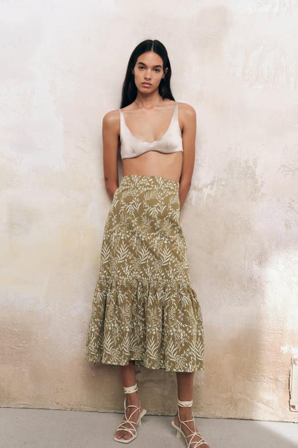 En verde caqui, con detalle de bordados combinados a contraste en color blanco y diseño floral, esta falda midi de Zara de tiro alto y bajo acabado en volante podemos comprarla por 39,95 euros. 