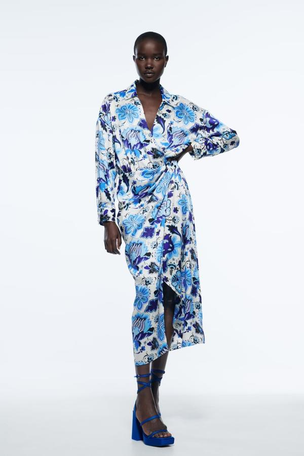 Fondo blanco y estampado de flores en varios tonos de azul para este vestido midi con cuello de solapa con escote de pico cruzado y mangas largas acabadas en puño. Con detalle de frunces delanteros, bajo con abertura frontal y cierre cruzado con botones, cuesta 39,95 euros. 