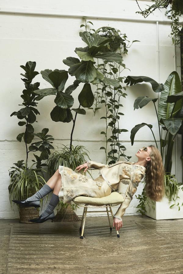 Chaqueta y falda de flores bordadas, calcetines altos y salones destalonados, todo de Miu Miu. Las gafas de sol son de Anna Karin Karlsson.