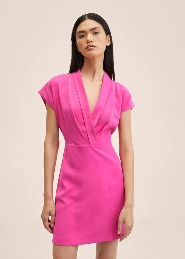 En tejido fluido y rosa fucsia, este vestido corto de diseño recto de Mango viene con escote cruzado de pico y mangas sisa. Tiene un precio de 35,99 euros. 