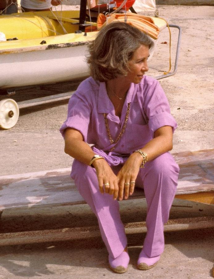 En los años ochenta la reina utilizó con frecuencia uno de los diseños más emblemáticos de su estilo of duty: el jumpsuit. Aquí lleva uno en color lila, combiando con otro de sus must, las zapatillas de esparto. 