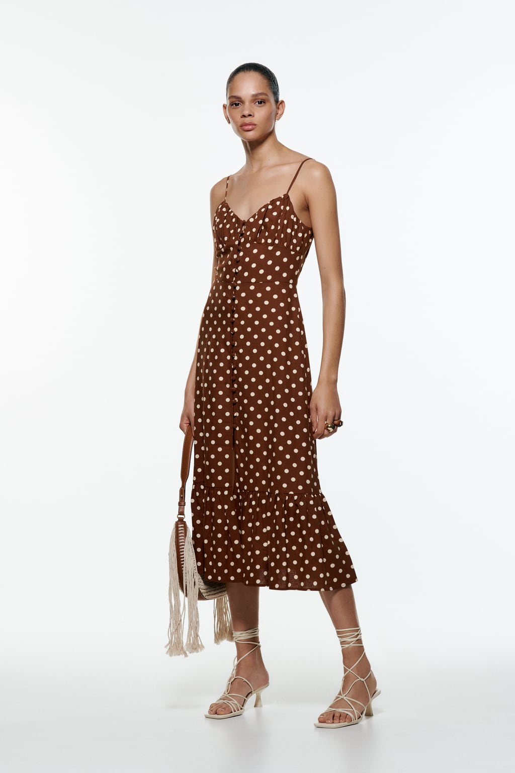El marrón chocolate es uno de esos tonos que suele ir asociado al frío pero realmente tiene muchas más posibilidades. Sobre un vestido de tirantes, típicamente veraniego, puedes conseguir el look más sofisticado. Vestido midi de Zara (29,99 euros) 