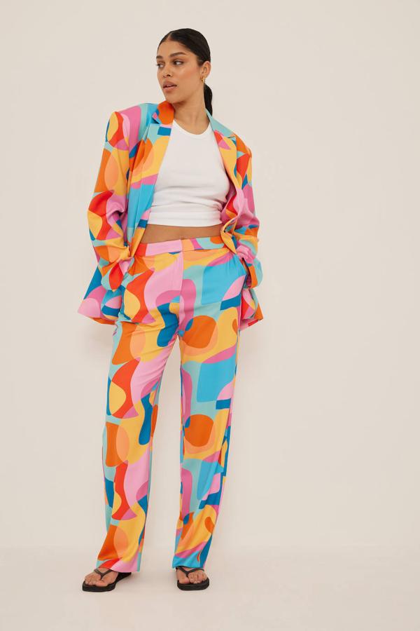 Traje de NA-KD con print abstracto multicolor. Este dos piezas conjunta blazer oversize con hombreras pronunciadas y pantalón de tiro medio con pernera ancha. Su precio es de 101,95 euros y 76,95 euros, respectivamente.