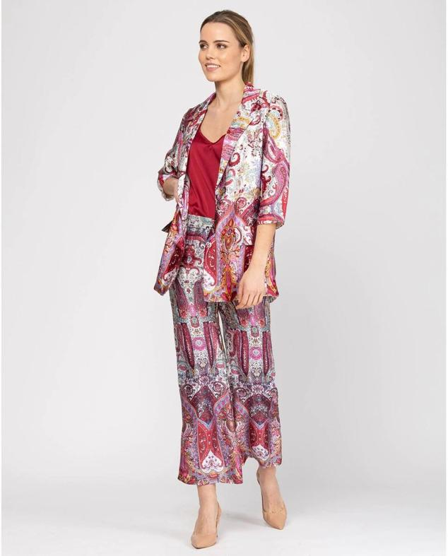 Traje de tejido satinado con estampado estilo pañuelo multicolor. La parte de arriba es una blazer de silueta relajada con manga tres cuartos a 119,90 euros. Y, la prenda inferior es un pantalón recto tobillero con tiro alto y cintura elástica, por 59,90 euros. Es de la marca Niza y lo encontrarás en El Corte Inglés.