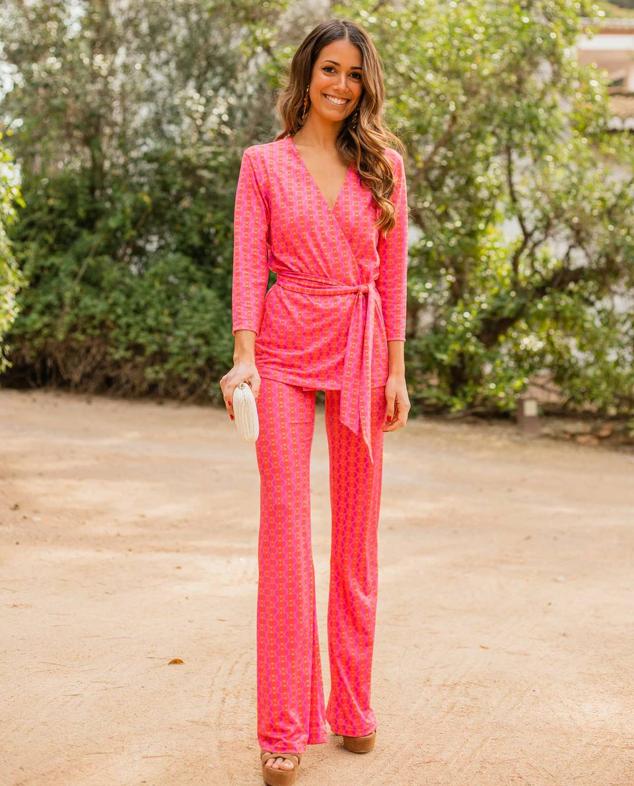 Traje de The Are con estampado geométrico en color rosa. Se compone de chaqueta cruzada sin solapa y cierre mediante cinturón de lazada a juego, más un pantalón elástico de tiro alto y diseño ligeramente acampanado. Las prendas tienen un precio de 49,95 euros y 42,95 euros, respectivamente.