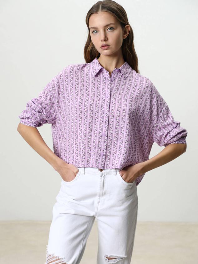 Camisa de diseño corto y holgado con manga larga y estampado de rayas verticales y flores, color lila. Está en la colección de Lefties por un precio de 8,99 euros.
