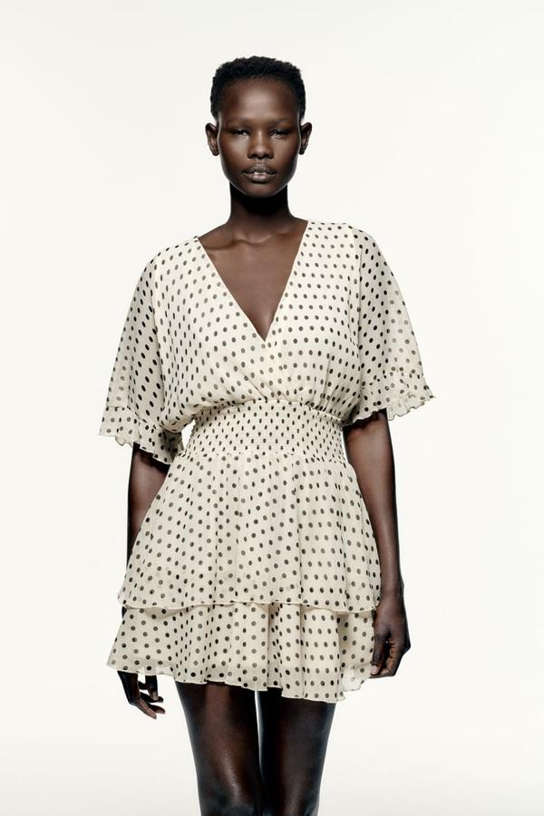 En crudo con estampado de lunares, este vestido con escote de pico cruzado y mangas cortas acabadas en volantes viene con cintura con elástico y forro interior combinado a tono y cuesta 29,95 euros. 