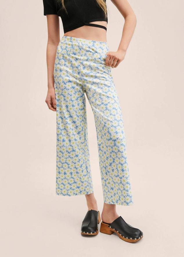 Pantalón tipo culotte con estampado floral de margaritas en tono azul claro y blanco. Están confeccionados con tejido elástico, tienen tiro alto, pernera ancha y largo tobillero. Cuenta con cierre de cremallera y dos bolsillos decorativos en la parte delantera. Lo encontrarás en Mango rebajado a 25,99 euros, de las tallas 32 a la 46 y también en color verde.