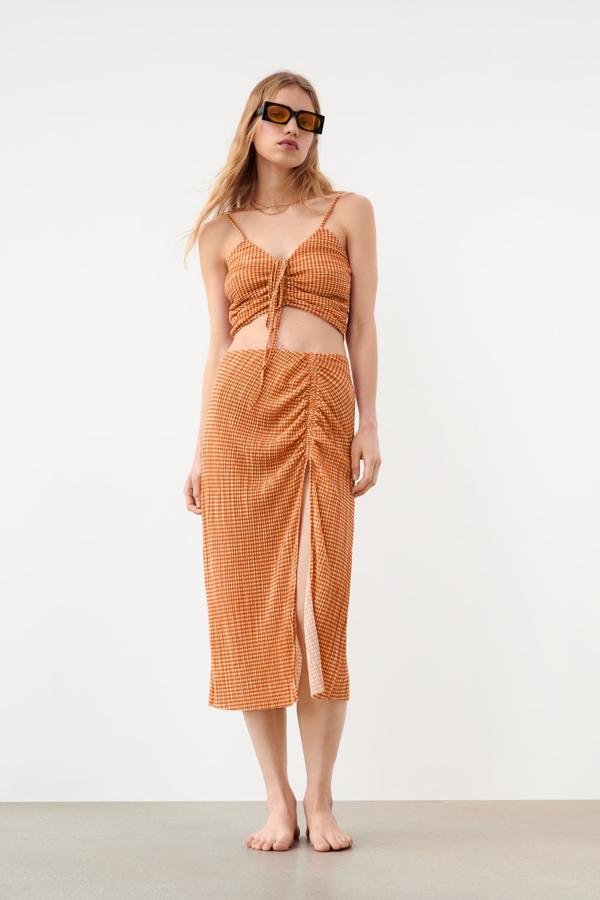 La falda midi es otras de las prendas que no podía faltar en esta selección. Y hemos elegido una que apuesta por un tono inesperado, como es el naranja. Llévala con un crop top a juego para tus planes más informales. Falda con abertura de Mango (17,99 euros) 