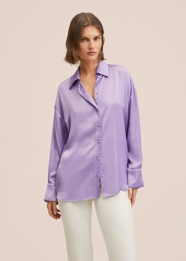 Camisa fluida de tejido satinado, fit oversize, manga larga terminada en puño con botones joya y cierre delantero con botones a tono, en lila, de Mango. Tiene un coste de 39,99 euros.