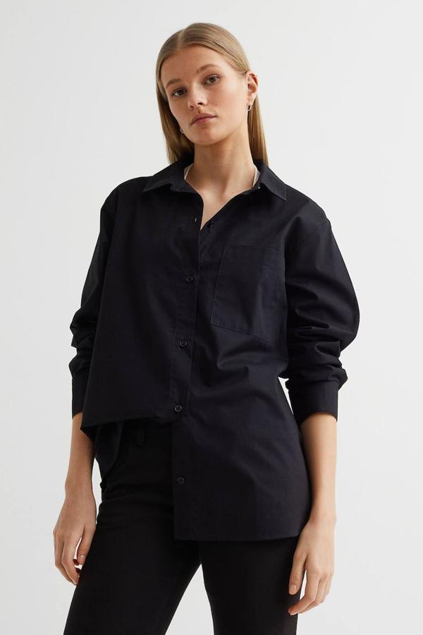 Camisa en tejido de algodón vaporoso con fit oversize, hombros caídos, bolsillos de plastrón y cierre mediante botones, en negro, de H&M. Está disponible a 14,99 euros.