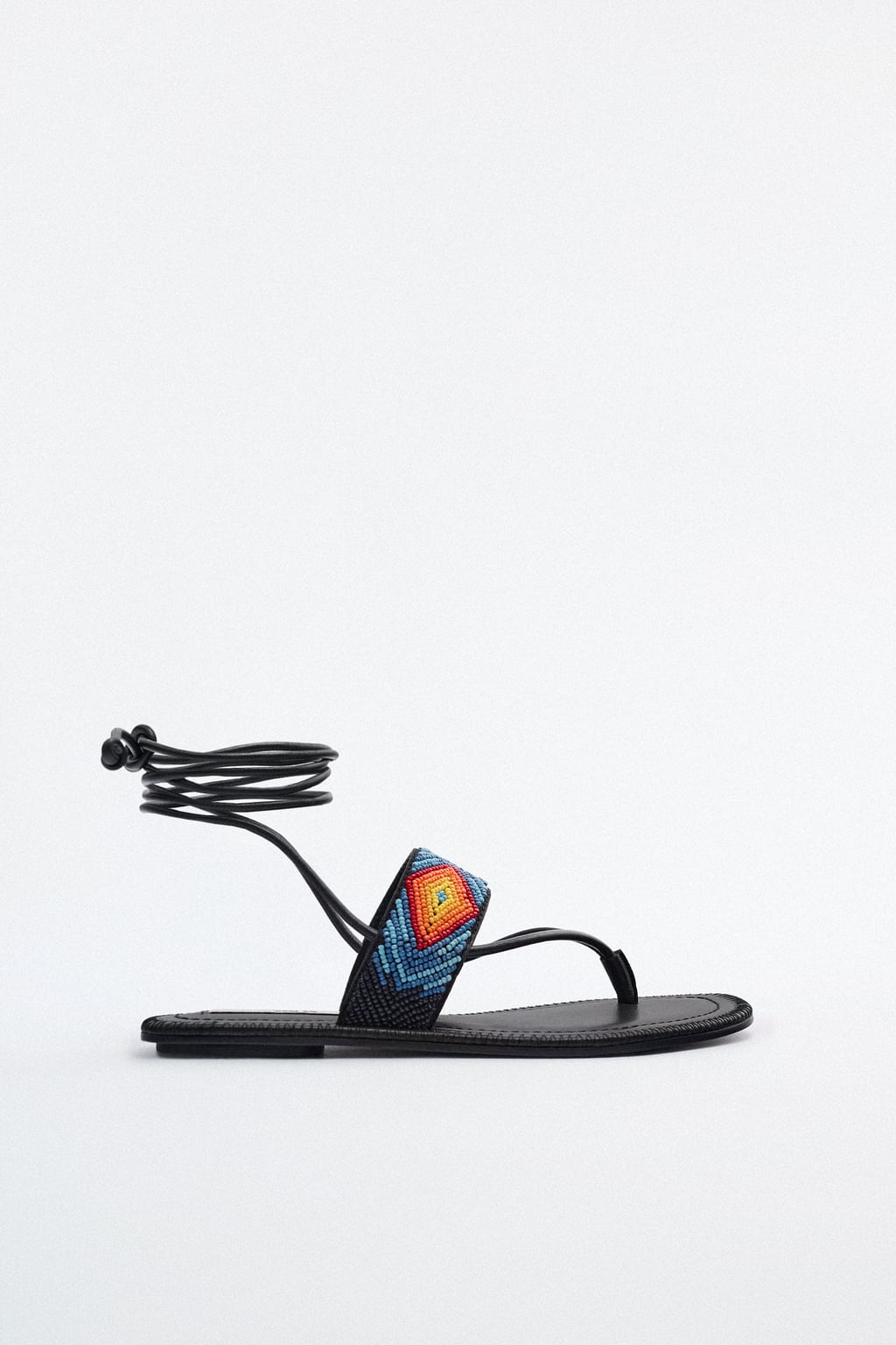 Otra propuesta donde los abalorios de colores son los protagonistas. De color negro y con cintas para anudar al tobillo, se convertirán rápidamente en tus favoritas del verano. Sandalias planas de Zara (39,99 euros). 