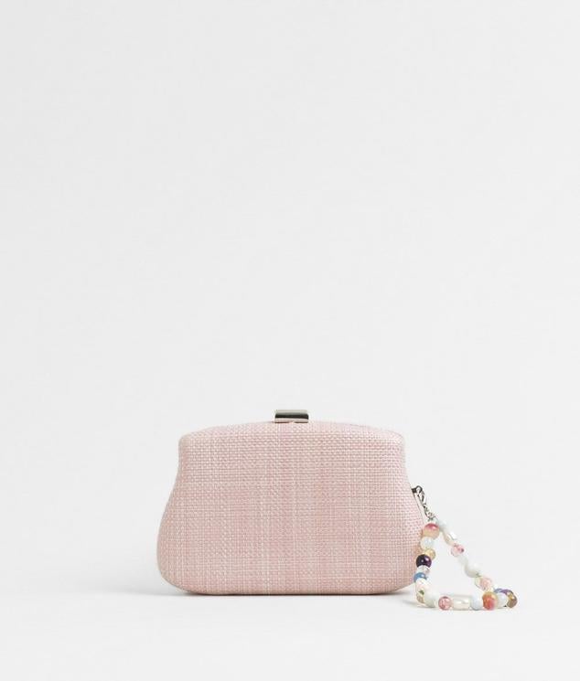 Paco Martínez presenta este clutch en rosa bebe con efecto rafia, y además con el detalle de un asa de mano de bolas multicolor. Cuesta 19,99 €.