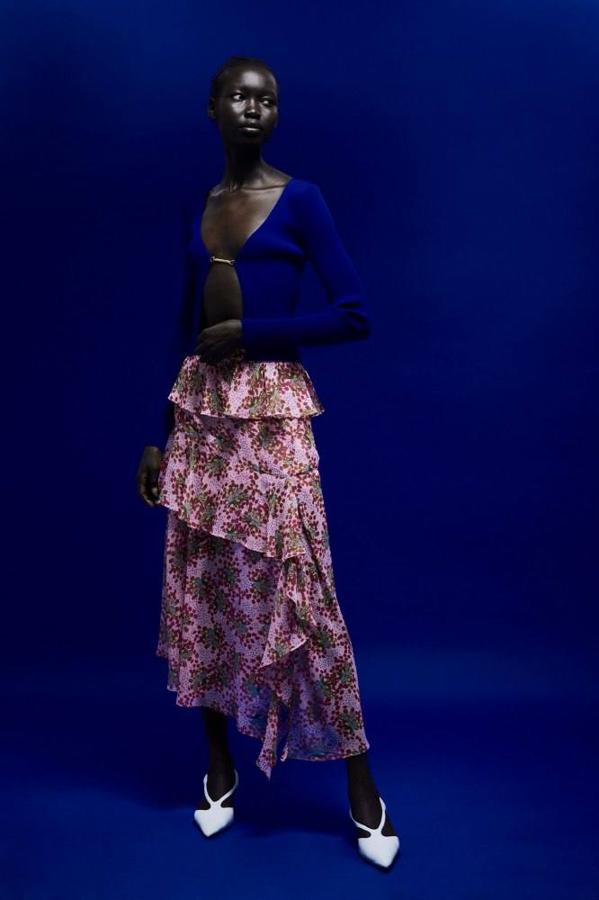 Falda midi de tejido vaporoso con talle alto, detalles de volantes, abertura lateral en el bajo y estampado de flores en color rosa. Está disponible por 29,99 euros en las tallas S, M y L.