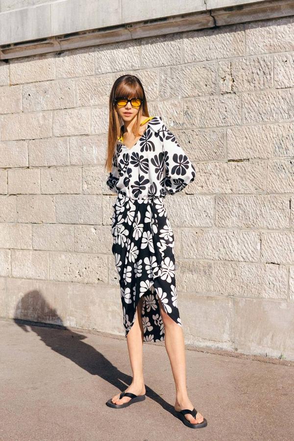 Falda midi fruncida estilo pareo don detalle de volante, bajo asimétrico y estampado bicolor en blanco y negro. Tiene un precio de 29,99 euros y está disponible en las tallas S, M y L.