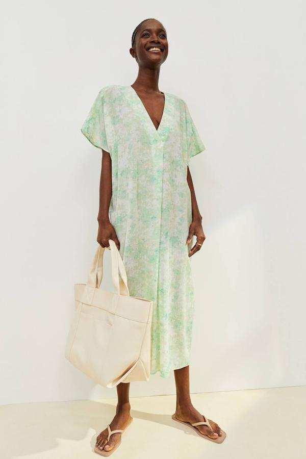 Vestido caftán midi con tejido ligero, escote de pico pronunciado, manga corta y detalle de pliegue delantero, en estampado floral verde claro, de H&M. Puedes encontrarlo a 29,99 euros.