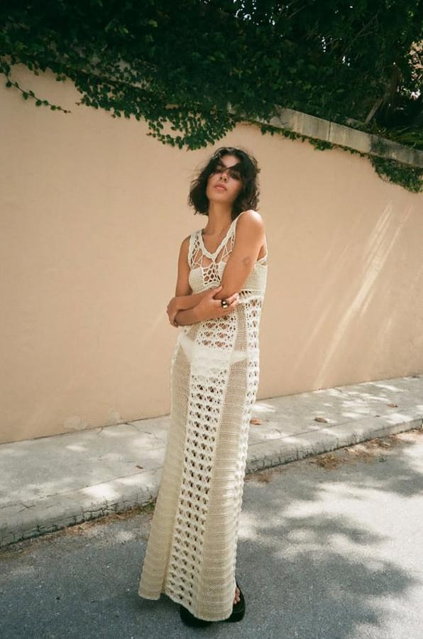 Vestido de punto calado con escote redondo y manga sisa en color crudo. No cuenta con forro, por lo que el calado hace que se transparente. Precio: 59,95 euros.