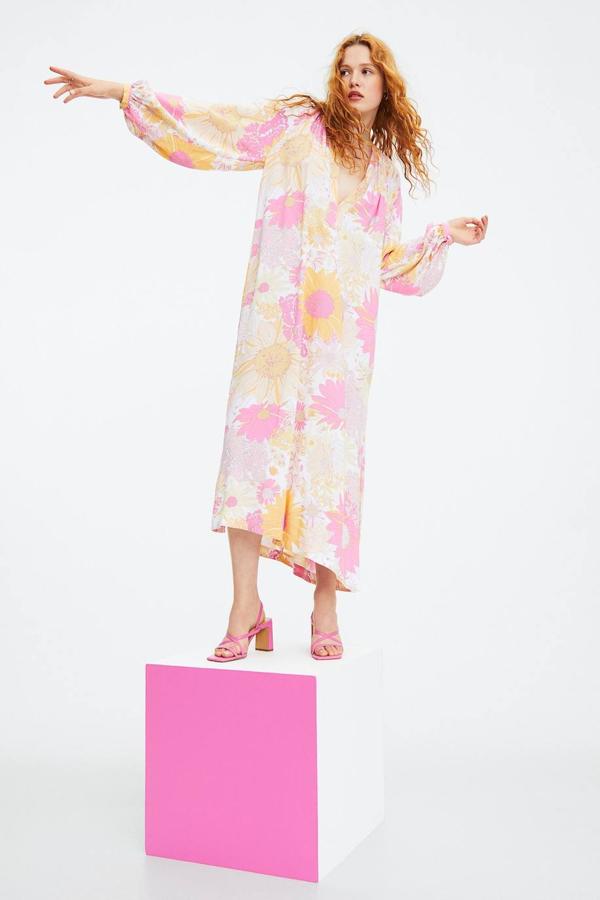 Vestido midi de estampado floral mulicolor con corte amplio, mangas largas abullonadas, escote de pico y aberturas laterales en el bajo. Tiene un coste de 29,99 euros.