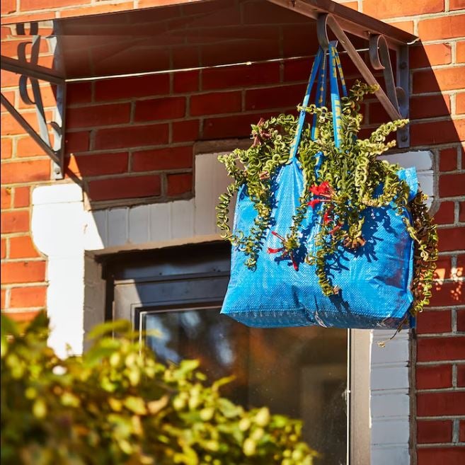 Si la famosa bolsa azul de IKEA inspiró a Balenciaga para crear un carísimo bolso viral, ¿quién te dice a ti que no puedes hacer un macetero colgante súper original con esta icónica pieza de menos de un euro? Pon tierra y fertilizante dentro y elige tus plantas favoritas, porque no tiene más misterio.