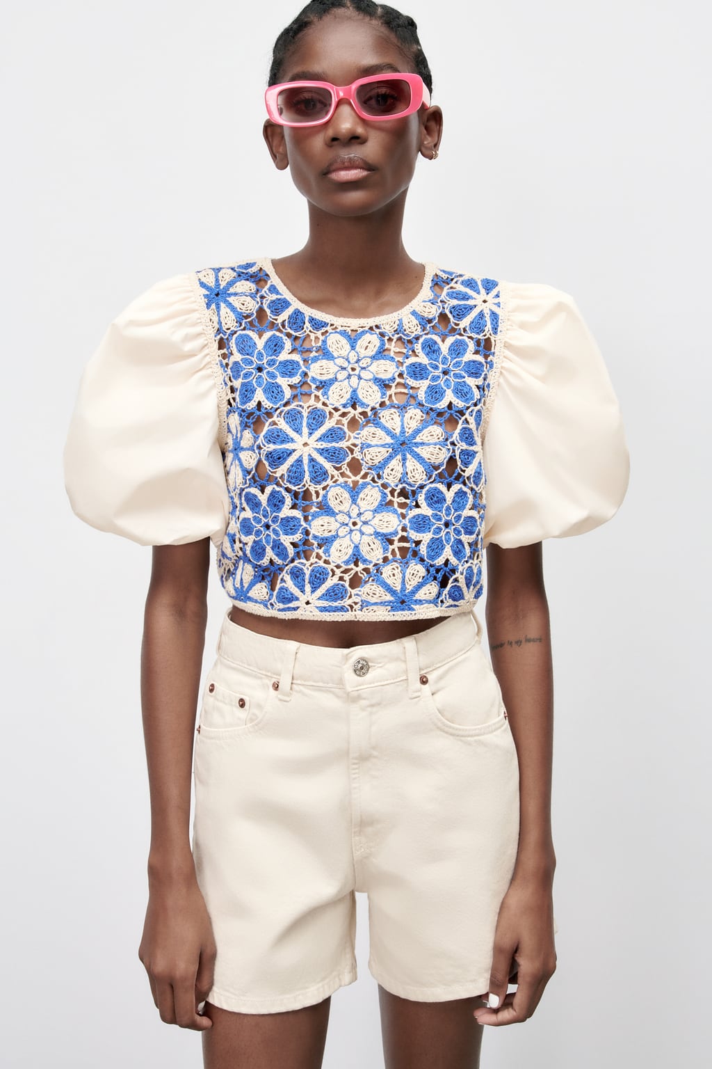 Una blusa con mangas abullonadas, con extra de volumen, es una de las propuestas más inesperadas de la colección de verano de Zara. El crochet en blanco y el azul ponen la guinda a una propuesta que no pasará desapercibida. Blusa calada de Zara (25,99 euros)