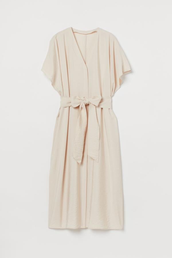 De corte midi y con tejido ligero de brillo, destacando sobre todo su escote de pico y mangas cortas amplias. Además, con cinturón de anudar ancho para estilizar la silueta. Pertenece a la nueva colección de H&M y podrás combinarla tanto con calzado de tacón como con sneakers. Precio: 29,99 €.