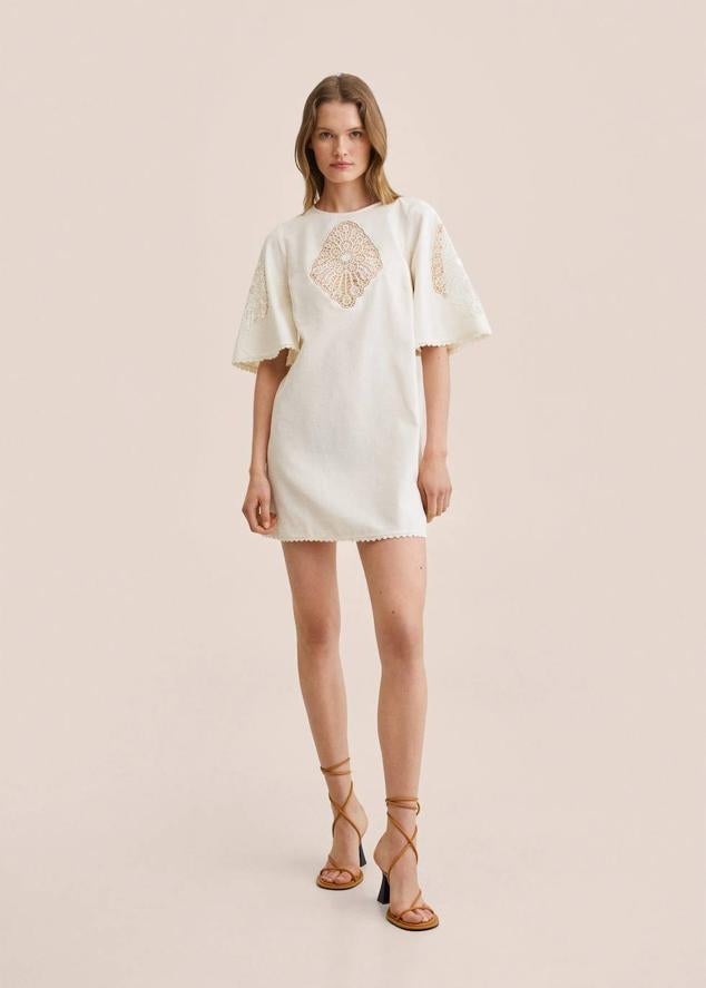 Vestido corto en tejido mezcla de lino y algodón, con diseño oversize, cuello redondo, manga corta y amplia, silueta recta y detalles calados y bordados, de Mango. Puedes comprarlo por 49,99 euros.