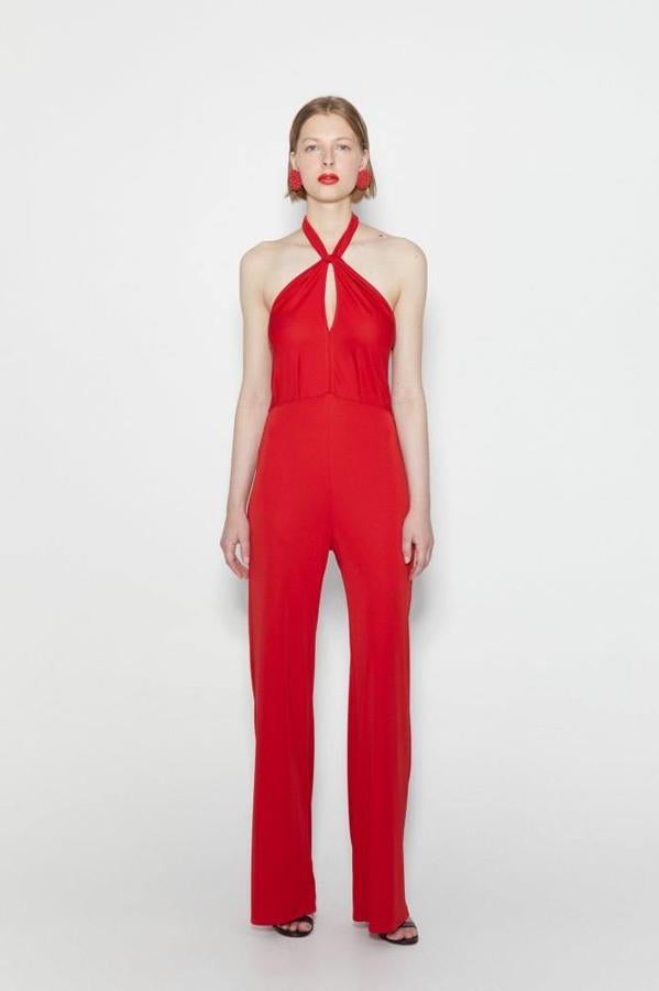 Mono de tejido elástico con pernera fluida, cuello halter con abertura delantera y espalda al aire, de Sfera. Lo puedes encontrar en versión lisa color rojo o con estampado azul, a 29,99 euros.