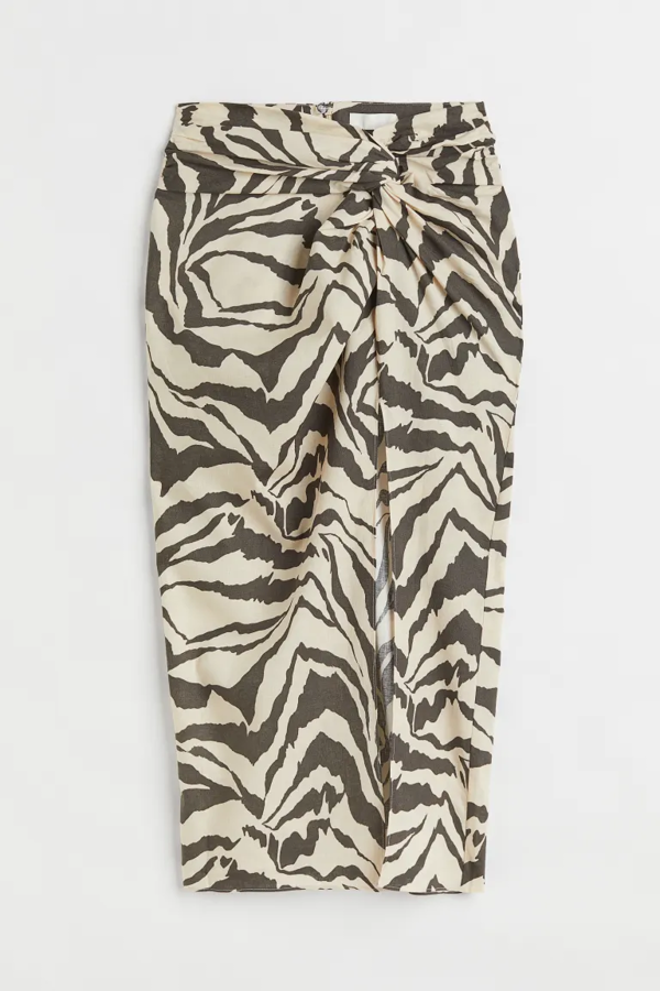 No hay nada más que le guste a una francesa que una falda midi drapeada. Son su as bajo la manga para todo. Para ir a la ofi, salir de compras, tomar algo por la noche… Y la verdad es que tiene su lógica, son muy combinables y, dada su asimetría, sientan muy bien a todo tipo de cuerpos porque acentúan la figura. Esta es de H&M (29,99 €).