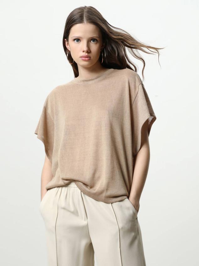 Camiseta confeccionada en tejido efecto lino ligero, con corte holgado, cuello redondo y manga corta amplia. Está disponible en 3 colores, blanco, arcilla y natural, por 6,99 euros.