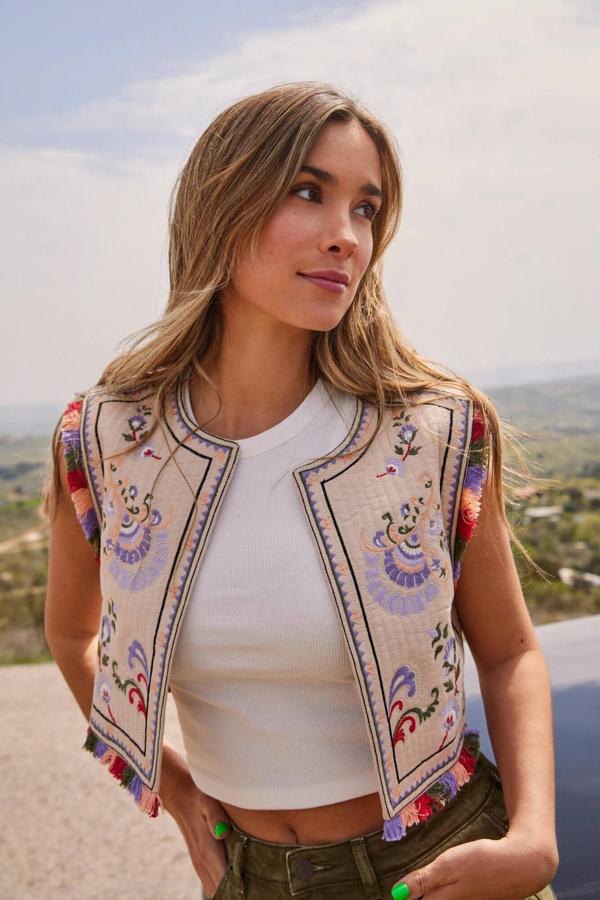 Chaleco efecto acolchado con cuello redondo, diseño abierto, detalles bordados multicolor y decoración desflecada en las terminaciones, en tono marrón. Lo encontrarás rebajado a 39,99 euros.