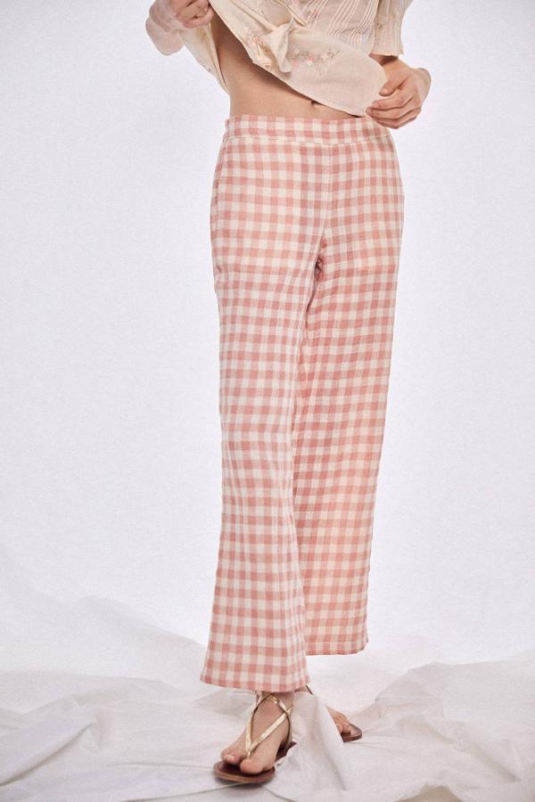 Pantalón largo ligero con pernera recta y holgada, tiro alto, cintura elástica, bolsillos laterales y estampado de vichy rosa y blanco, de Cortefiel. Lo encontrarás a 99 euros.