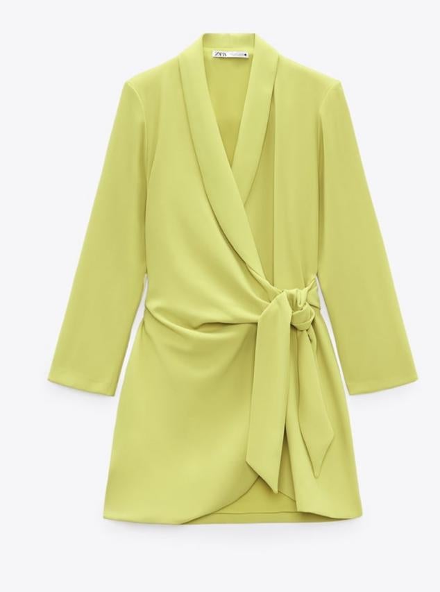 Vestido corto en color lima de cuello solapa y manga larga con hombreras. Cuenta con un detalle de pliegues laterales y un cierre frontal cruzado con lazadas tipo pareo, de Zara. Cómpralo por 39,95 euros. 