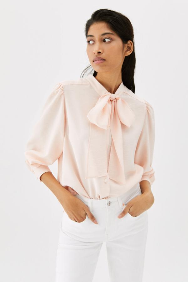 El detalle del lazo hace aún más especial esta blusa de Cortefiel. Puedes conseguirla en blanca o en rosa. Además, es reversible, por lo que puedes lucirla de cualquier manera. Precio: 19,99 €. 