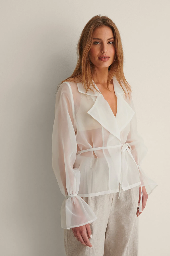 Diseñada por NA-KD en tela de organza y con transparencias. Podrás lucirla tras un día en la playa o piscina, garantizando que tu bronceado sea el protagonista. Precio: 56,95.