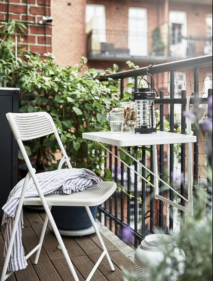 Un balcón estrecho también puede ser un comedor exterior, y la clave está en los muebles versátiles, como la mesa TORPARO de IKEA (19 euros), que podrás poner y quitar siempre que quieras (se cuelga de la barandilla), además de plegar para que no ocupe espacio.