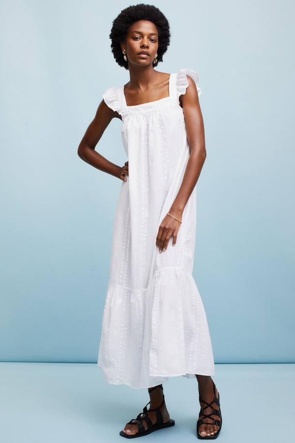 Vestido largo en tejido de sirsaca vaporosa color blanco, con escote cuadrado, tirantes anchos con volante, lazada en la espalda y falda escalonada con vuelo, de H&M. Su coste es de 39,99 euros y también lo puedes encontrar en negro y con estampado azul.