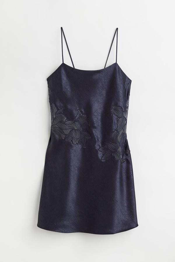 Con aires de los noventa y muy propio de las top models. Así es el vestido lencero con encajes en azul noche que nos presenta H&M. Precio: 49,99 €.