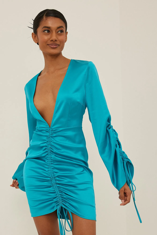 NA-KD crea un vestido corto con escote en V profundo, mangas de campana largas con cordón en los puños, un cordón por delante y una cremallera lateral. Precio: 48,96 €.