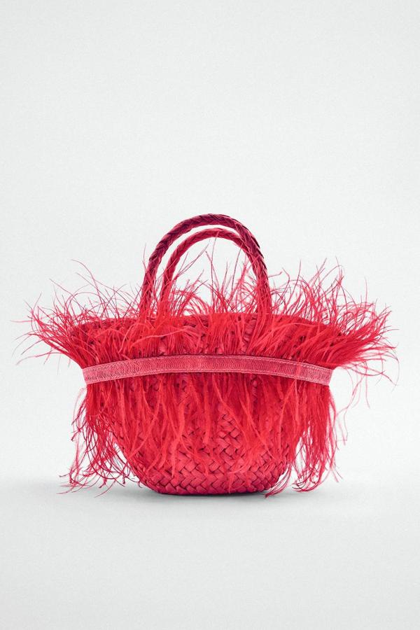 Bolso mini capazo con cuerpo trenzado, doble asa de mano, asa de cadena larga extraíble y detalles de adornos de plumas a tono, en rojo fresa o verde, de Zara. Lo encontrarás a 49,95 euros.