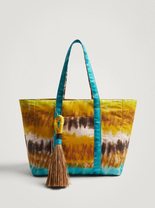 Bolso tipo shopper en tejido con estampado tie-dye color amarillo, marrón y azul. Tiene doble asa de hombre, cierre mediante cremallera bolsillo exterior y detalle de maxi colgante a juego. Lo encontrarás en Parfois a 25,99 euros.