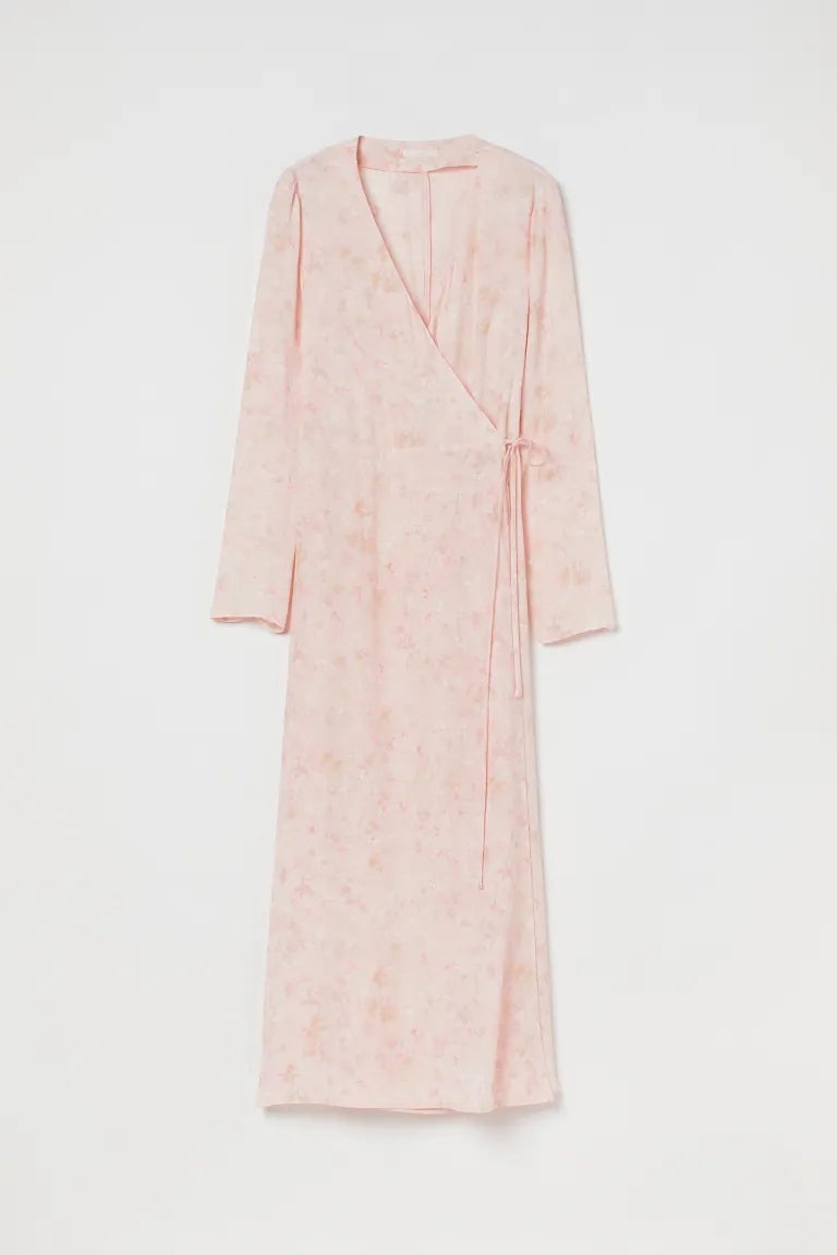 Vestido cruzado muy fluido con manga larga, y lazada en la zona de la cintura. Está disponible en rosa pastel, por 14,99 euros.